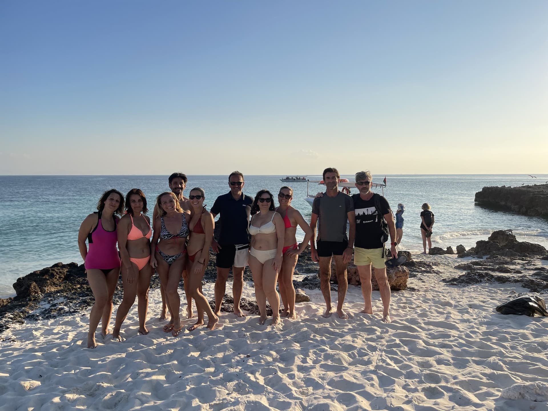 A group on the beach at golden hour after a Daymaniyat Islands trip