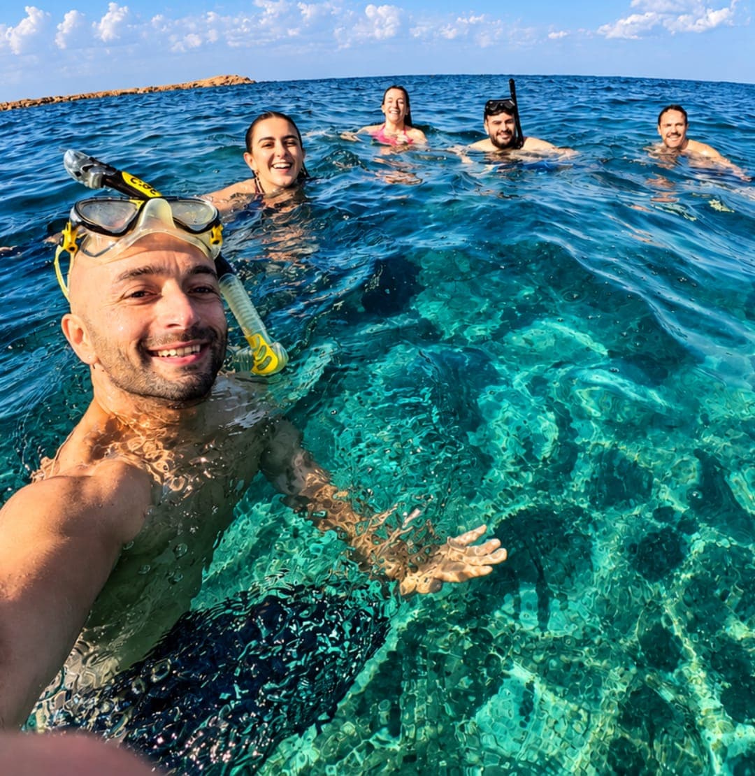 Smiling guests swimming in clear turquoise water on a Daymaniyat Islands snorkelling tour