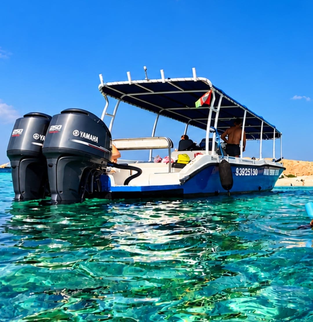 A Royal Marine Tours boat with twin outboard engines in turquoise water at the Daymaniyat Islands