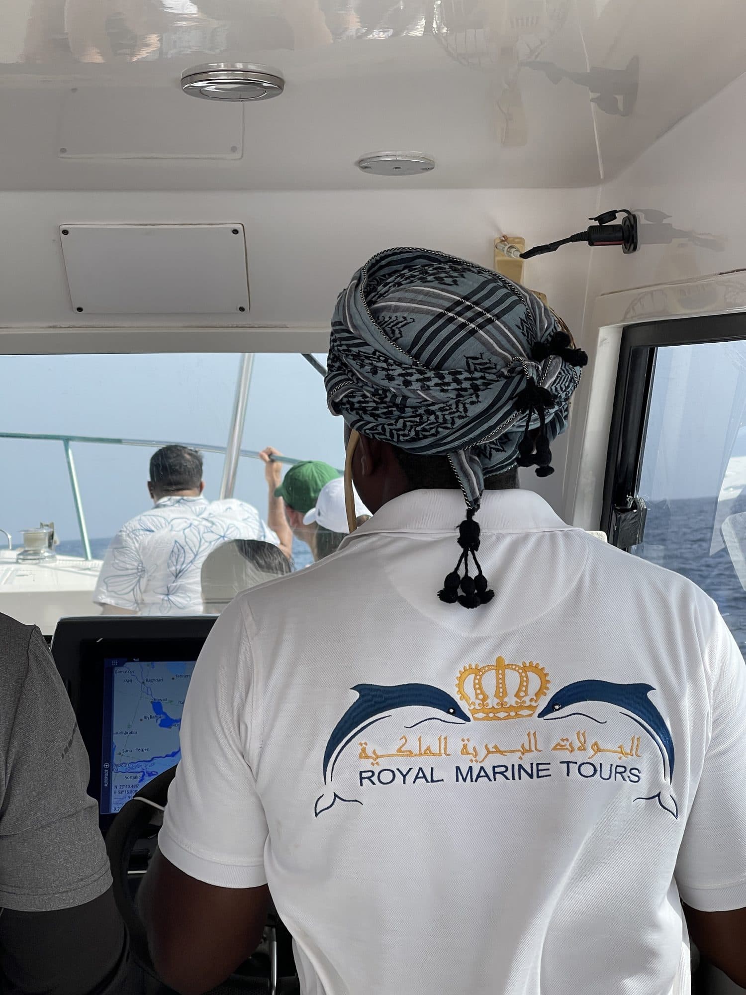 A Royal Marine Tours captain in a branded shirt aboard the boat