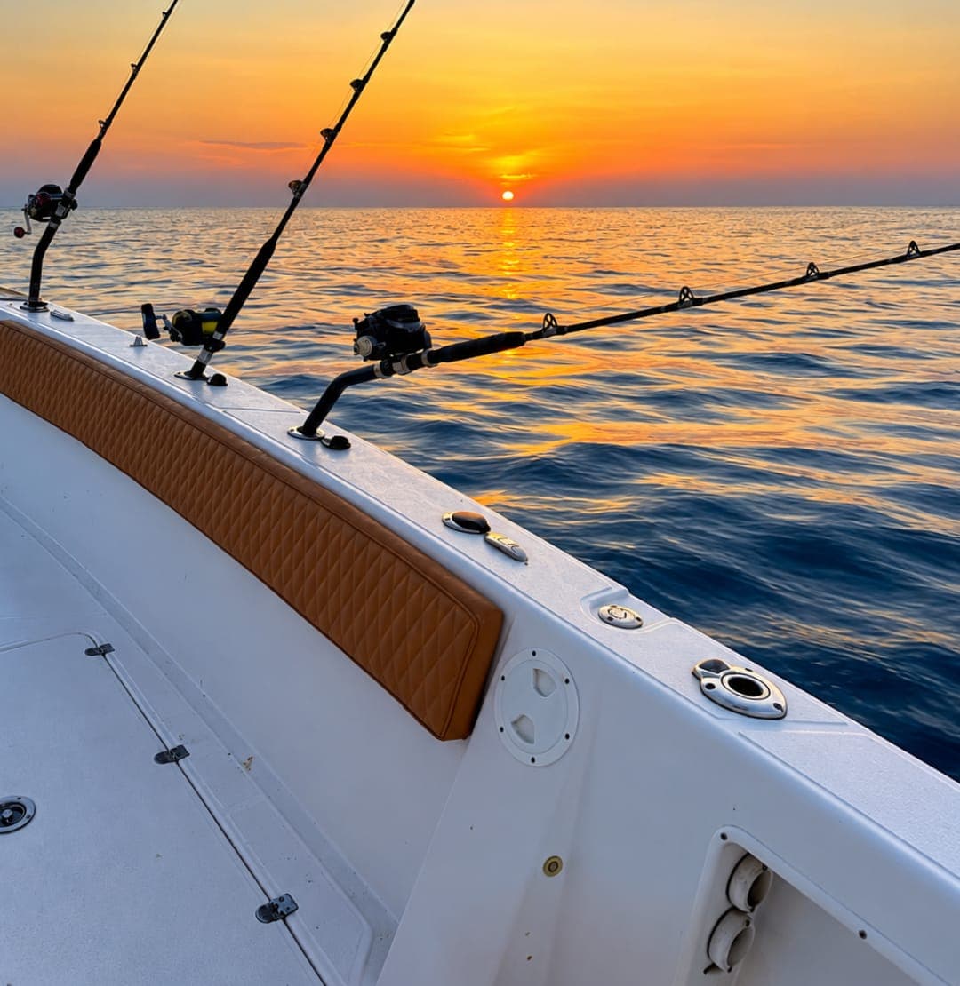 Fishing rods on a Royal Marine Tours boat at sunset over the Gulf of Oman, Muscat