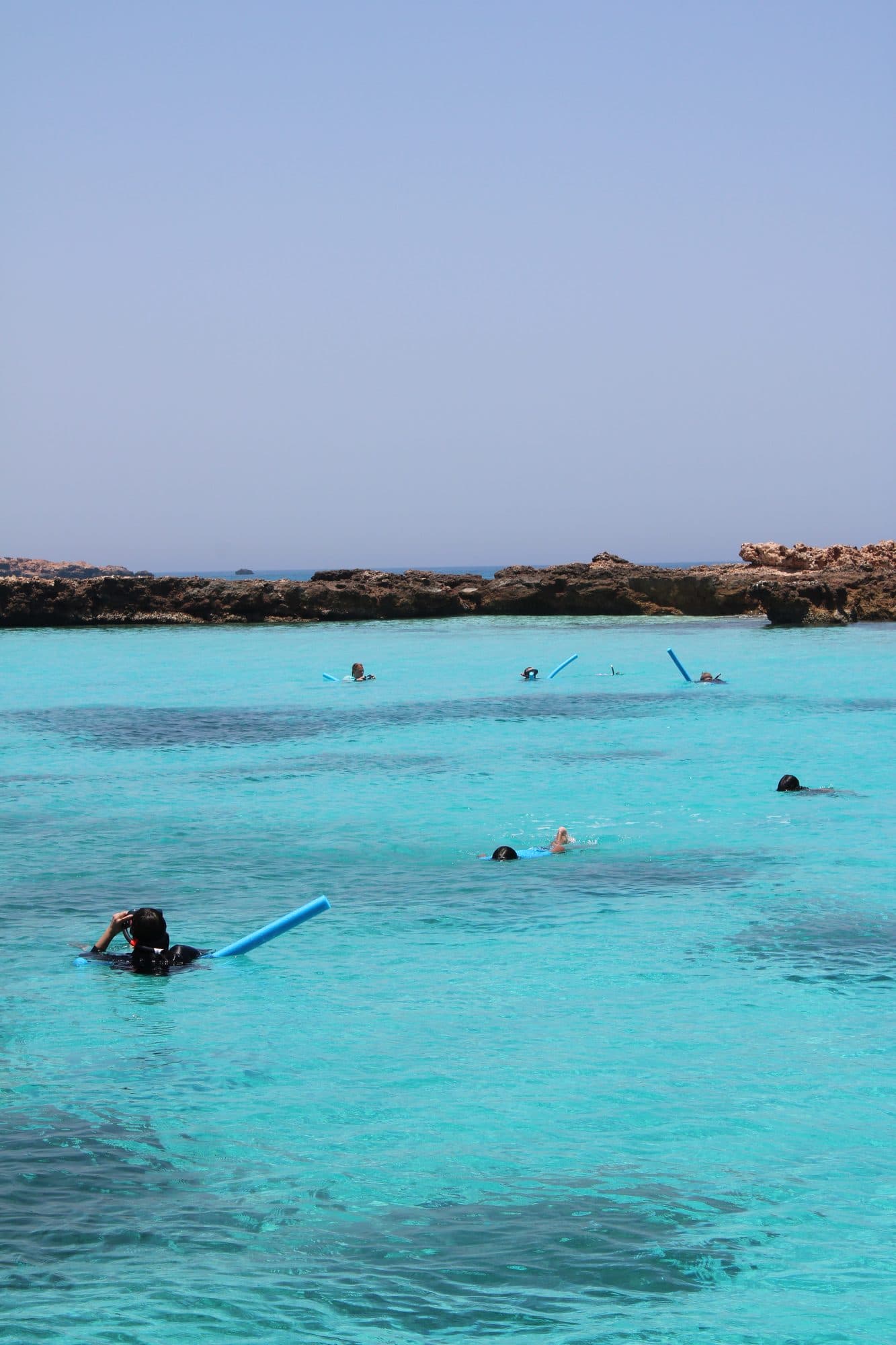 Snorkellers exploring a turquoise lagoon at the Daymaniyat Islands